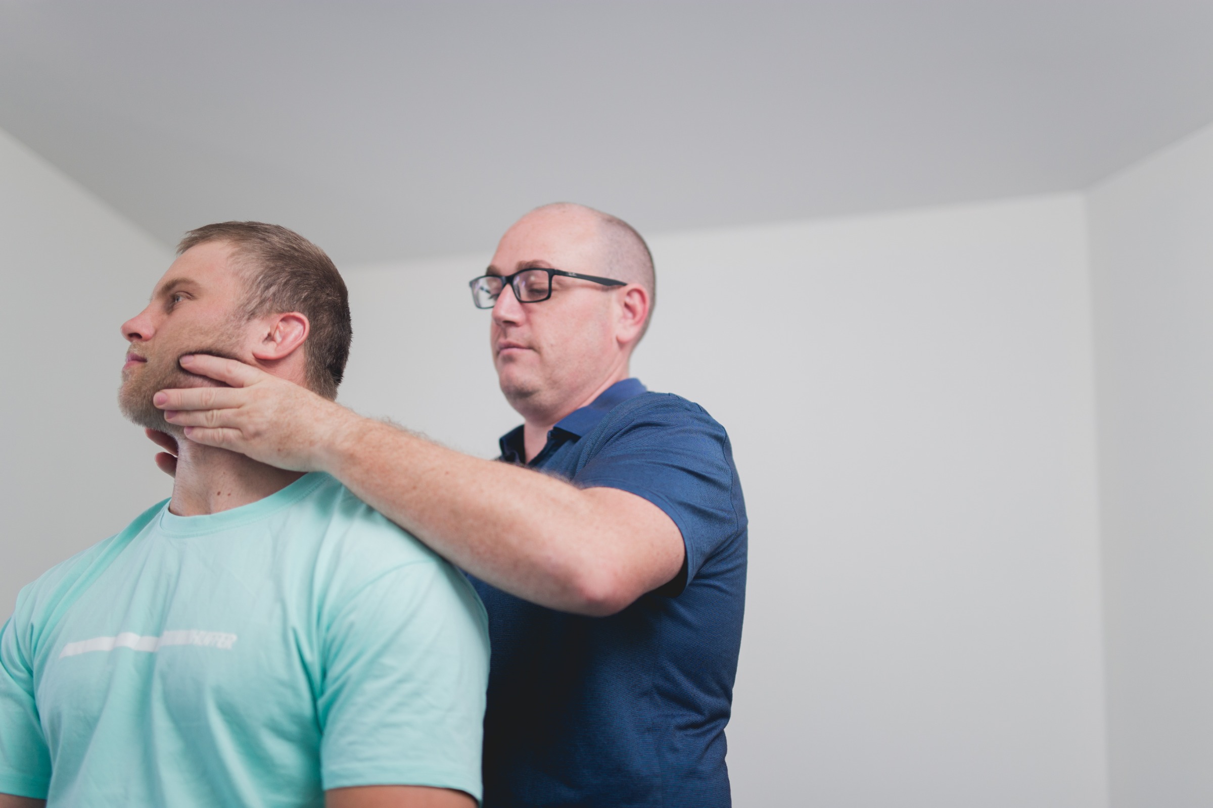A physiotherapist assessing a patient’s neck movement
