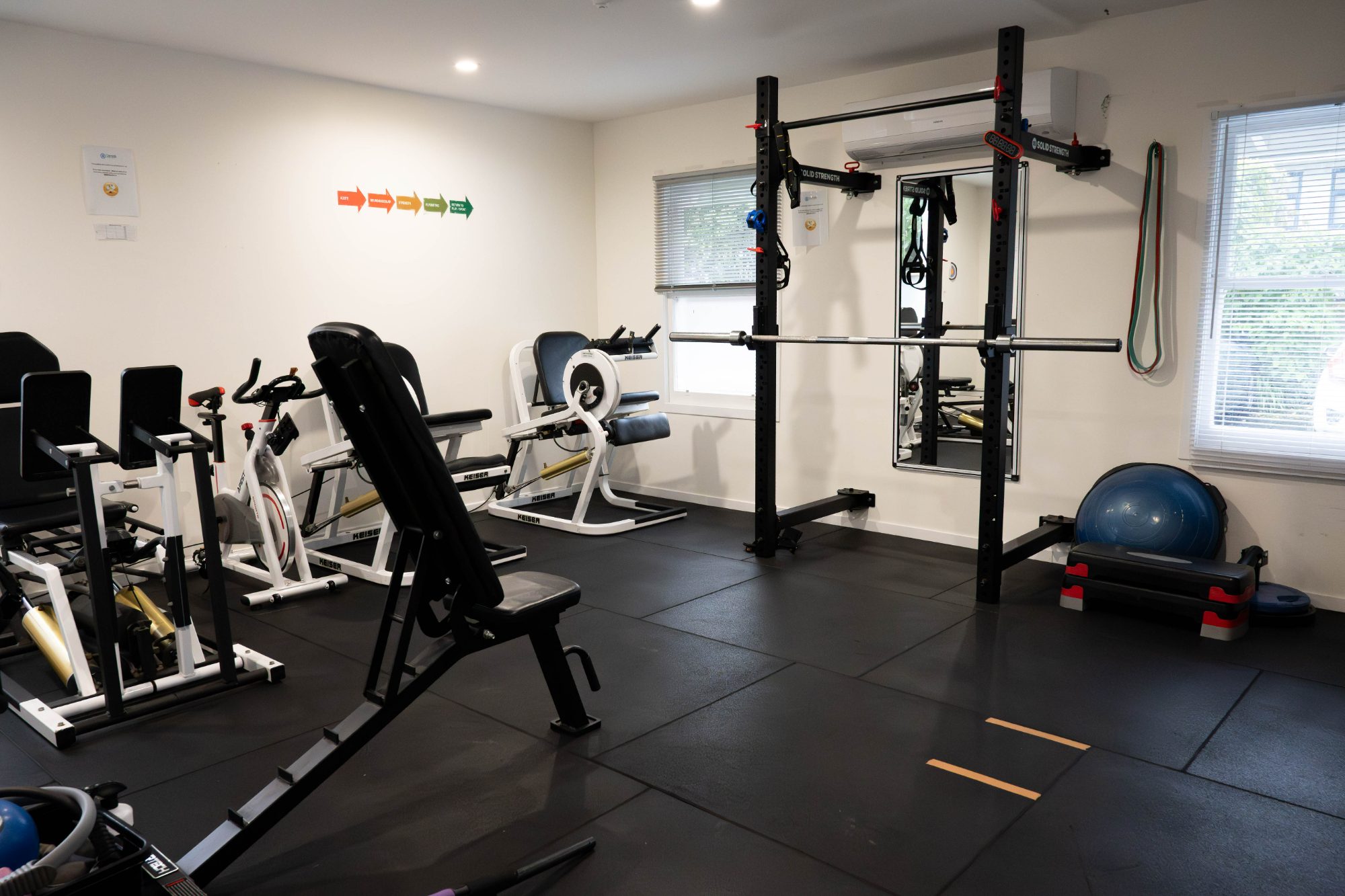 The Cairnhill rehabilitation gym with Keiser machines, a squat rack and a bench