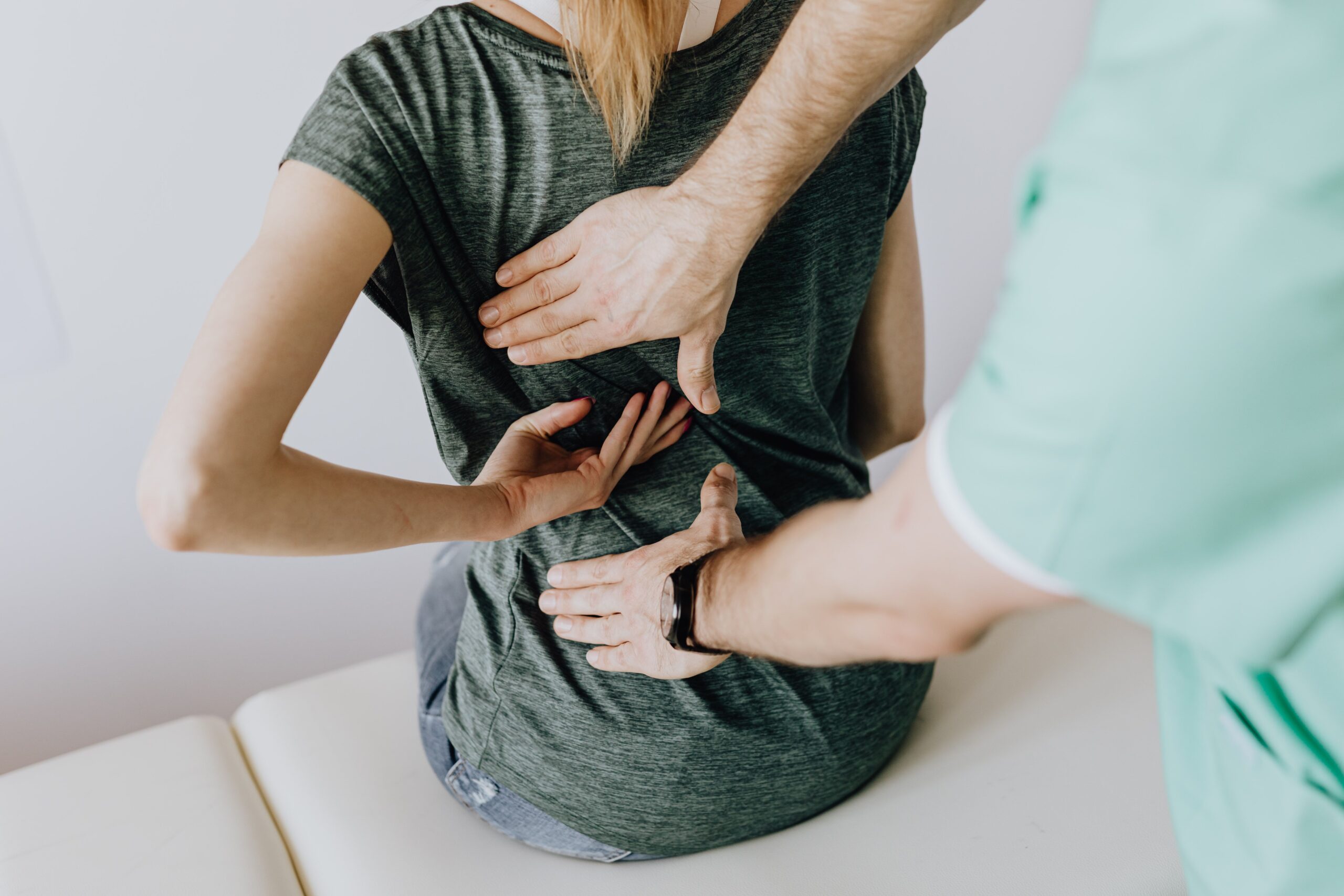 A physiotherapist assessing a patient’s lower back