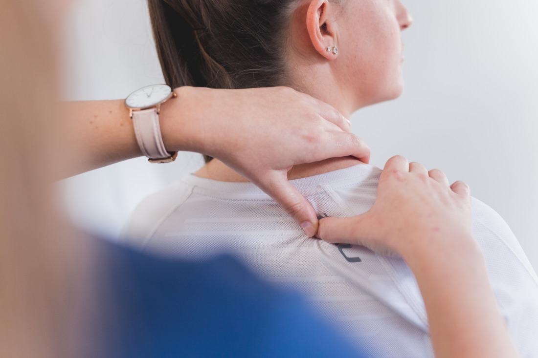 A physiotherapist assessing a patient’s neck movement