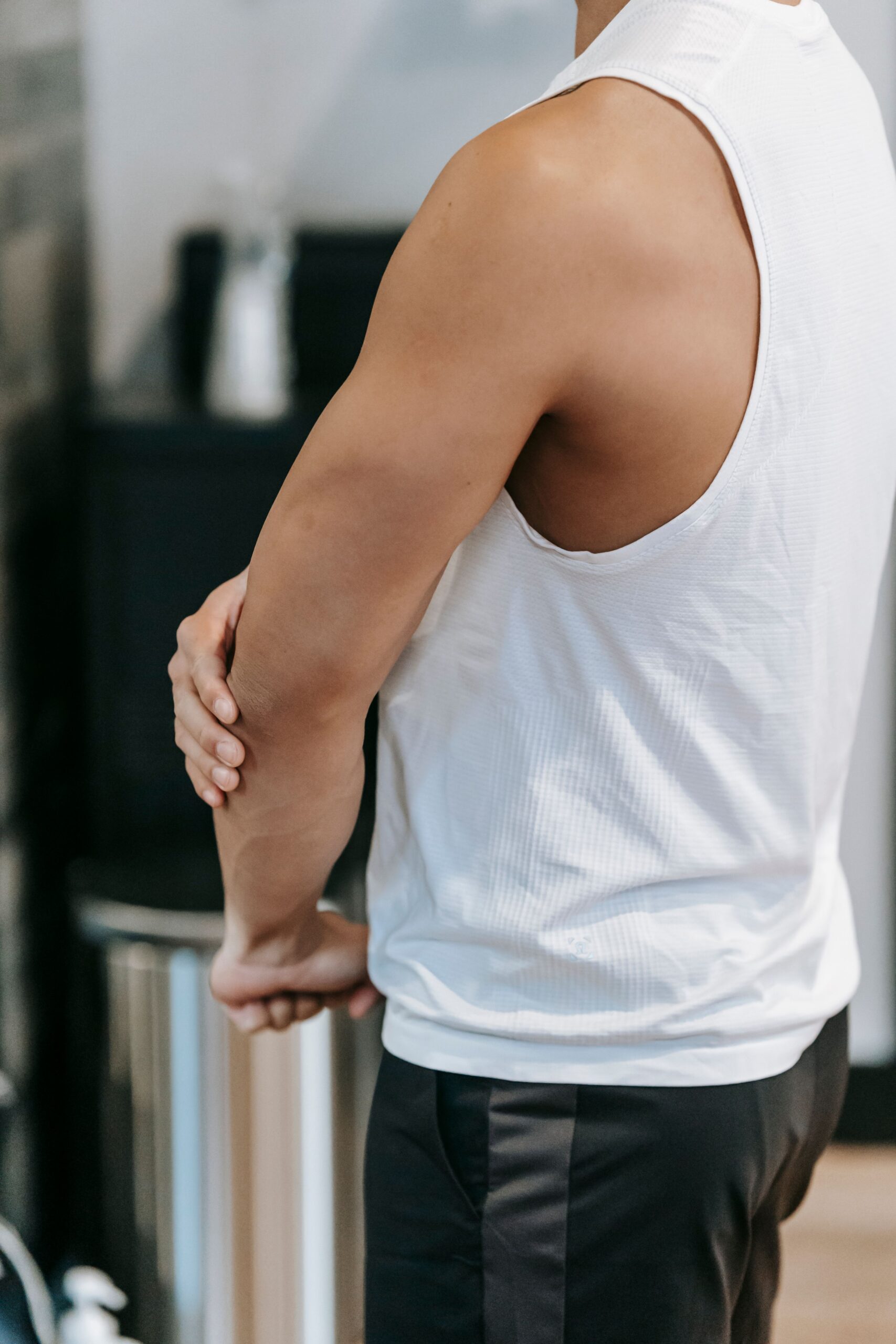 A man holding his elbow while stretching his forearm