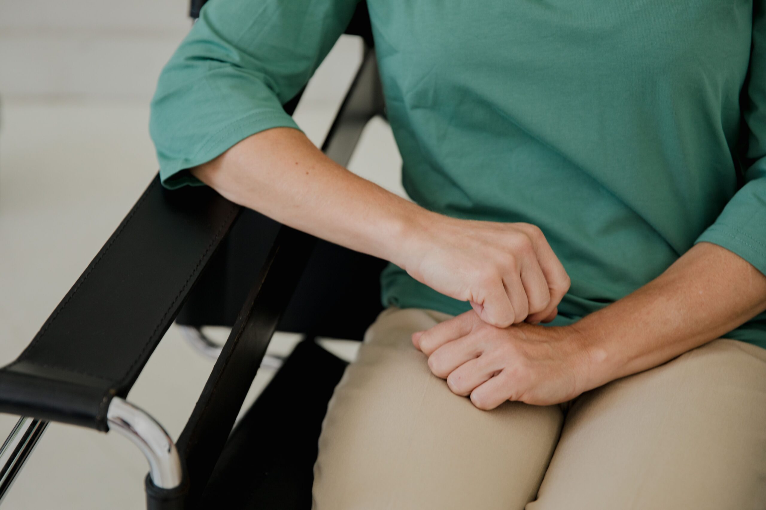 A patient seated in the clinic, resting his elbow on the chair arm