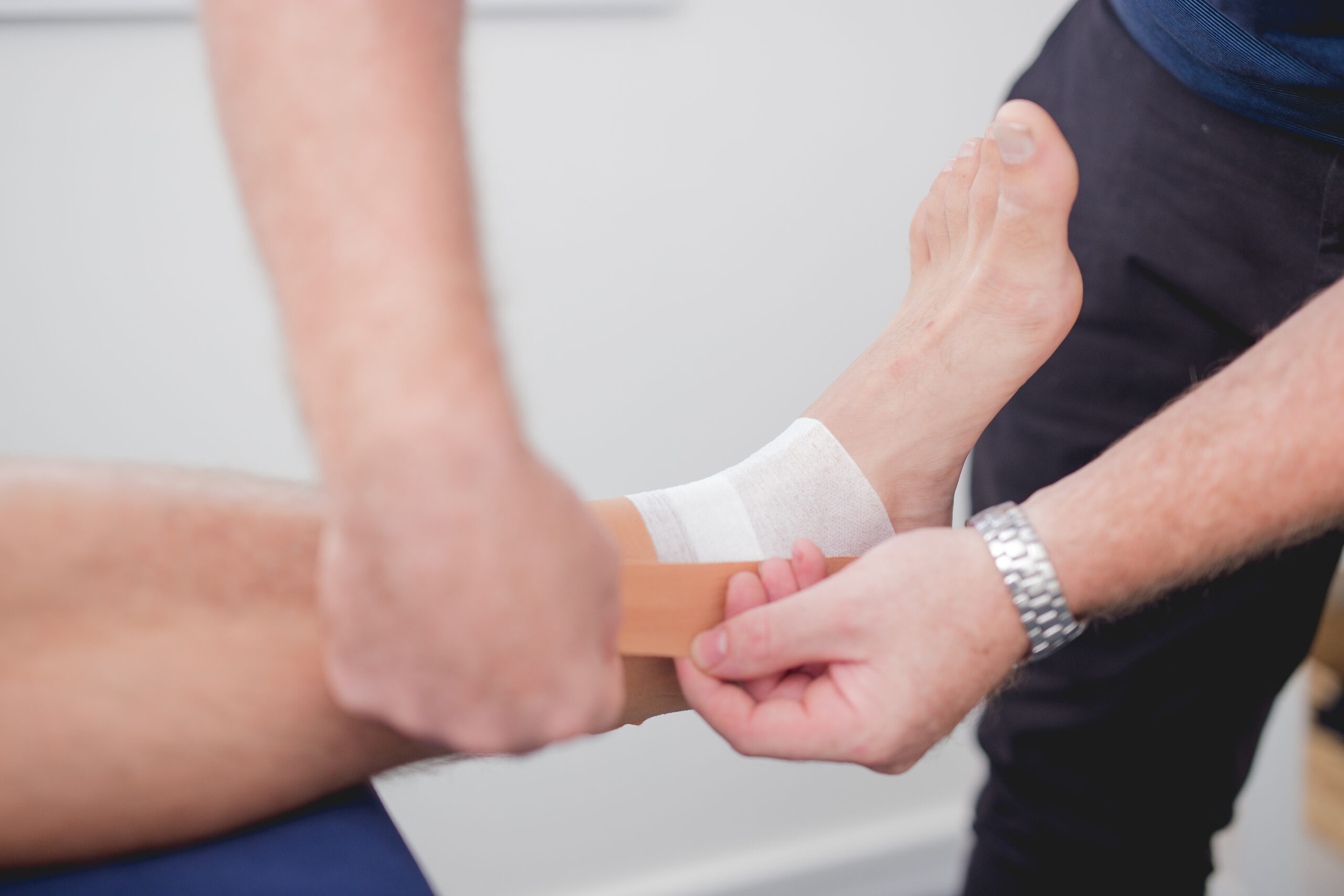 A physiotherapist taping a patient’s ankle