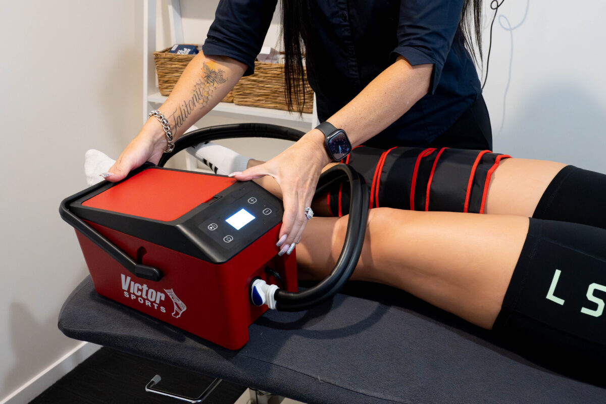 A therapist fitting a cold compression wrap to a patient's leg