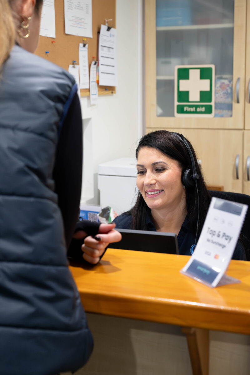 A patient paying at the Cairnhill Physiotherapy reception desk